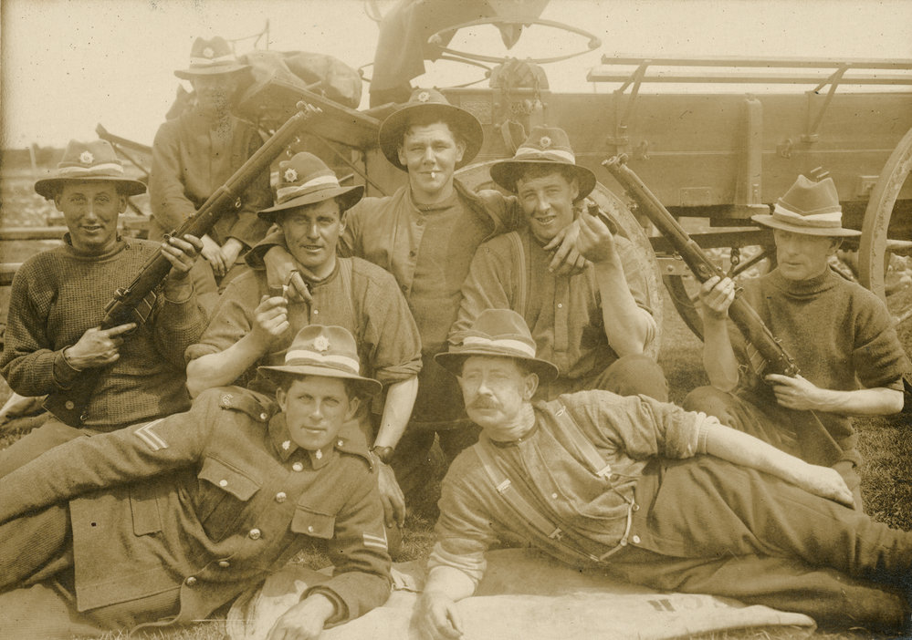 Soldiers and rifles in front of horse-drawn cart