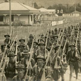 Soldiers marching down street 