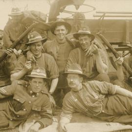 Soldiers and rifles in front of horse-drawn cart